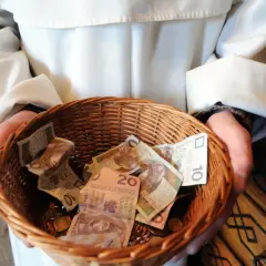 Kosz z pieniędzmi, pytanie ile bierze kościelny za pogrzeb. Widać banknoty 10 i 20 zł.