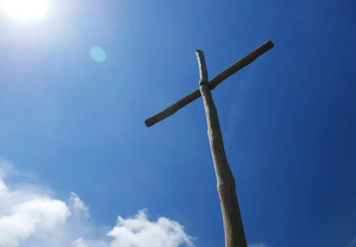 Drewniany krzyż na tle błękitnego nieba. Czy prawosławie to chrześcijaństwo? Symbol wiary.
