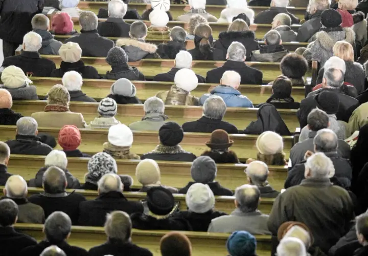 Ludzie siedzą w kościele, zastanawiając się, ile kosztują msze gregoriańskie. Wszyscy ubrani są ciepło, przygotowani na zimno.