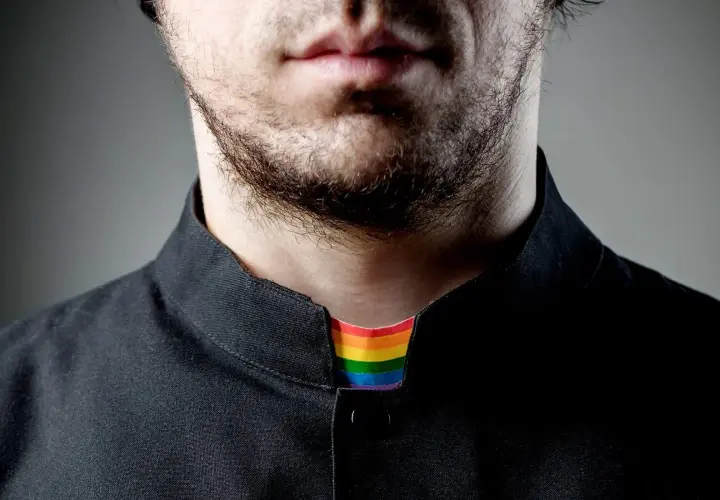 Broda i usta mężczyzny w czarnej koszuli. Widoczny tęczowy kołnierzyk, symbolizujący, co to jest pastor otwarty na wszystkich.