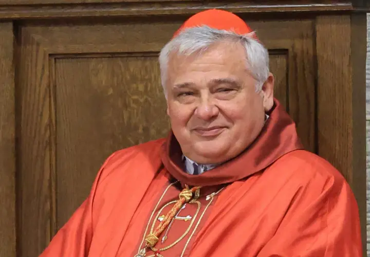 Uśmiechnięty kardynał w czerwonej sutannie i piusce. Kto jest nad biskupem? To on, w swojej uroczystej szacie.