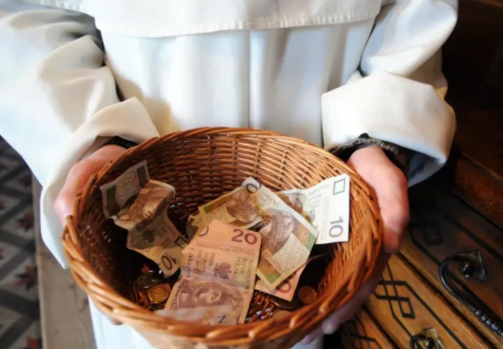 Kosz z pieniędzmi, pytanie ile bierze kościelny za pogrzeb. Widać banknoty 10 i 20 zł.