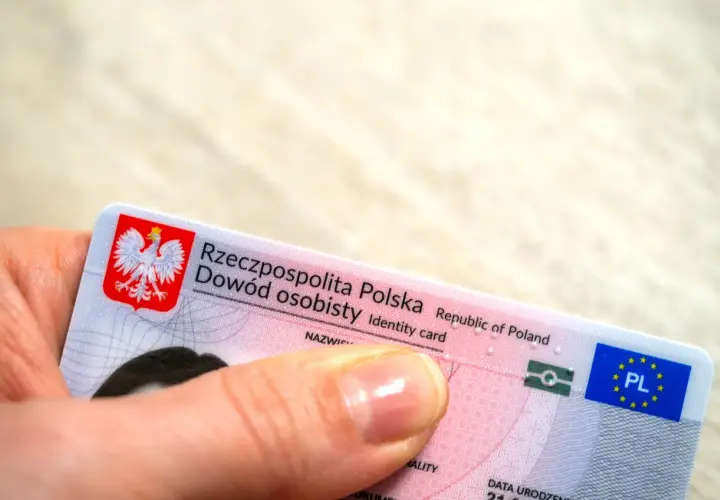 Dłoń trzyma polski dowód osobisty. Czy imię z bierzmowania jest w dowodzie? To pytanie nurtuje wielu Polaków.