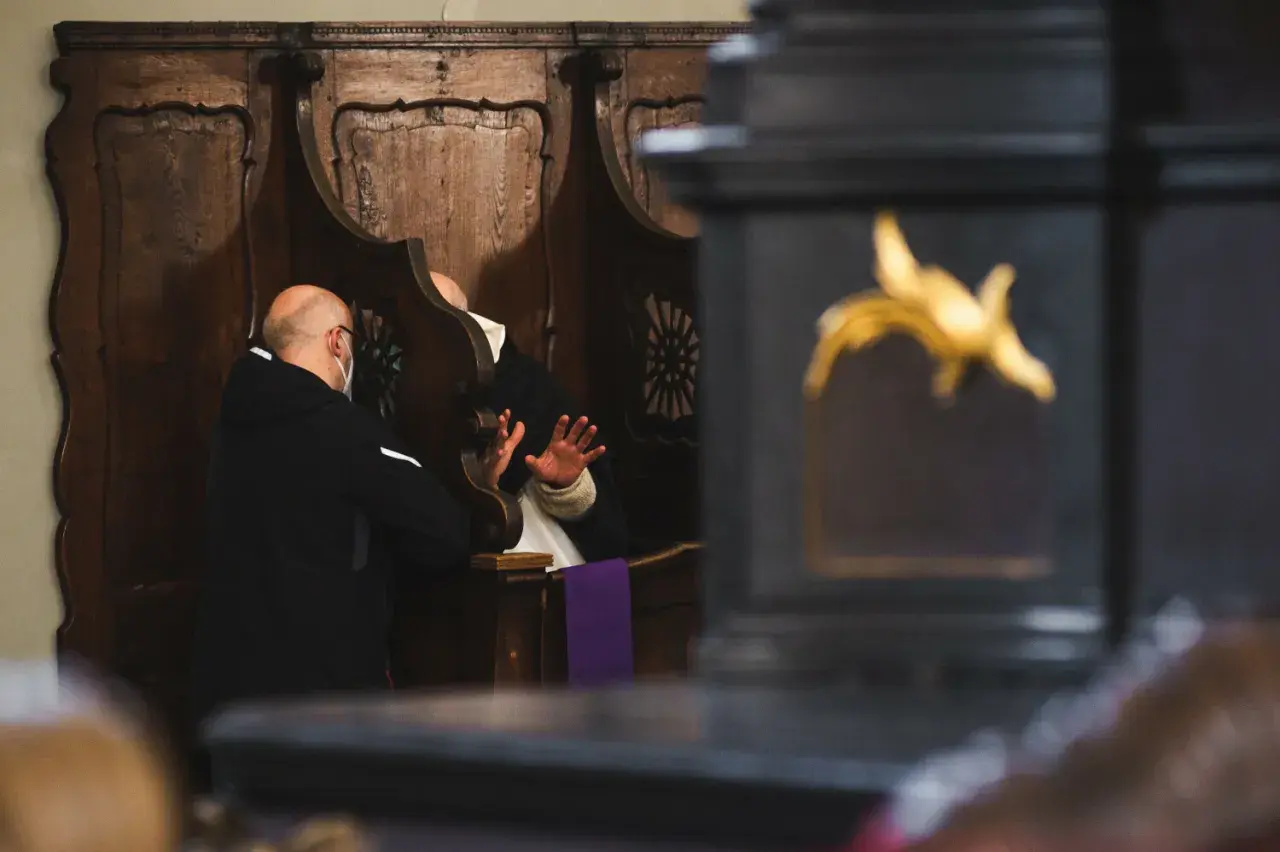 Spowiedź w konfesjonale. Mężczyzna w masce wyznaje swoje grzechy ciężkie, lista jest długa.