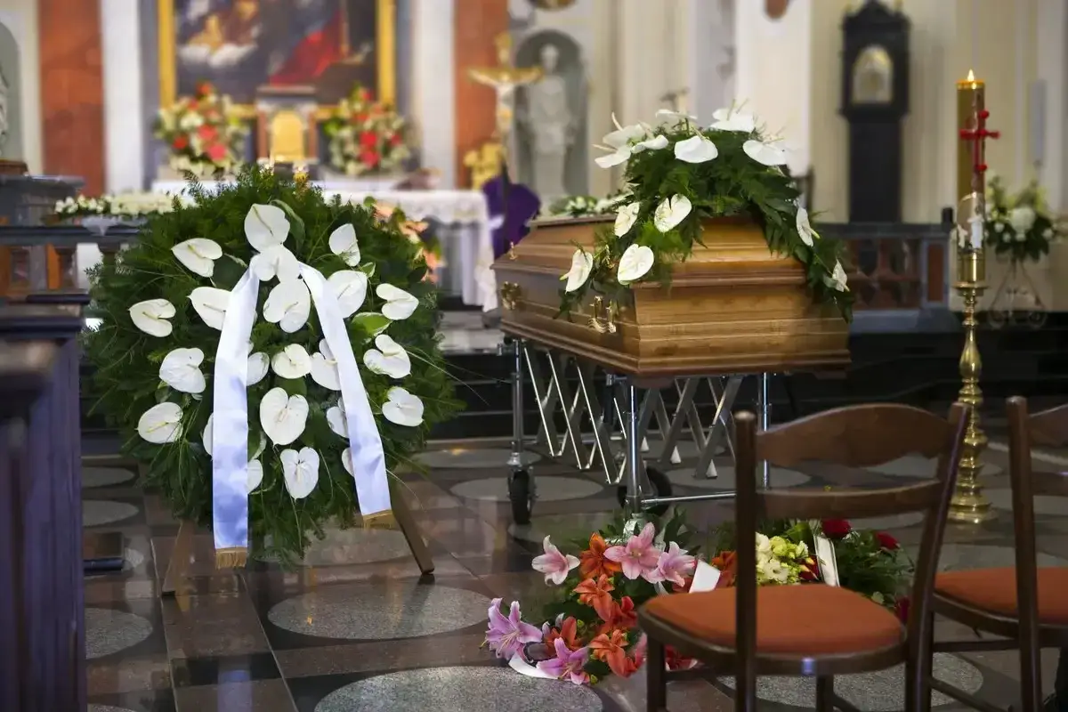 Trumna w kościele, wieniec pogrzebowy i kwiaty. Msza za zmarłego to czas zadumy i modlitwy.