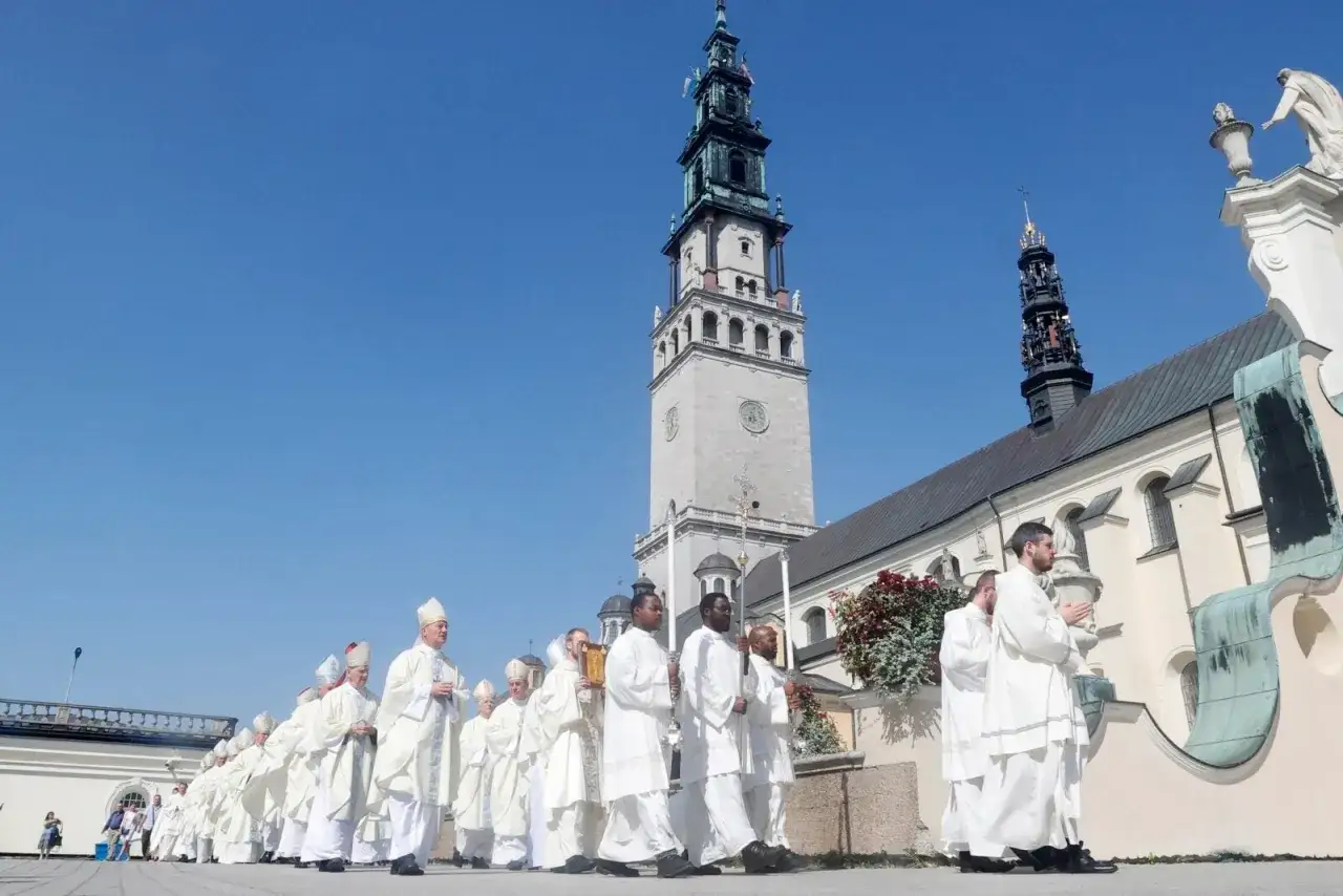 Procesja duchownych w białych szatach na Jasnej Górze. Intencje mszalne niesione w procesji.