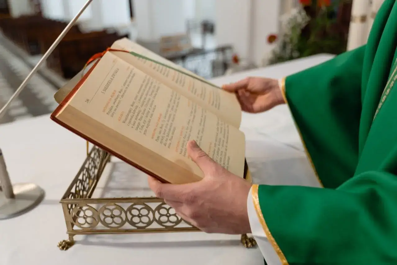 Kapłan w zielonej szacie czyta z księgi. Zastanawiasz się, ile trwa msza za zmarłego?