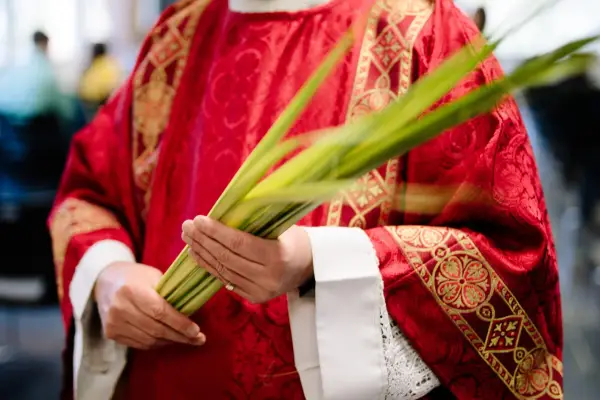 Kapłan w czerwonej, bogato zdobionej szacie trzyma gałązki palmowe. Długość mszy w Niedzielę Palmową zależy od parafii.